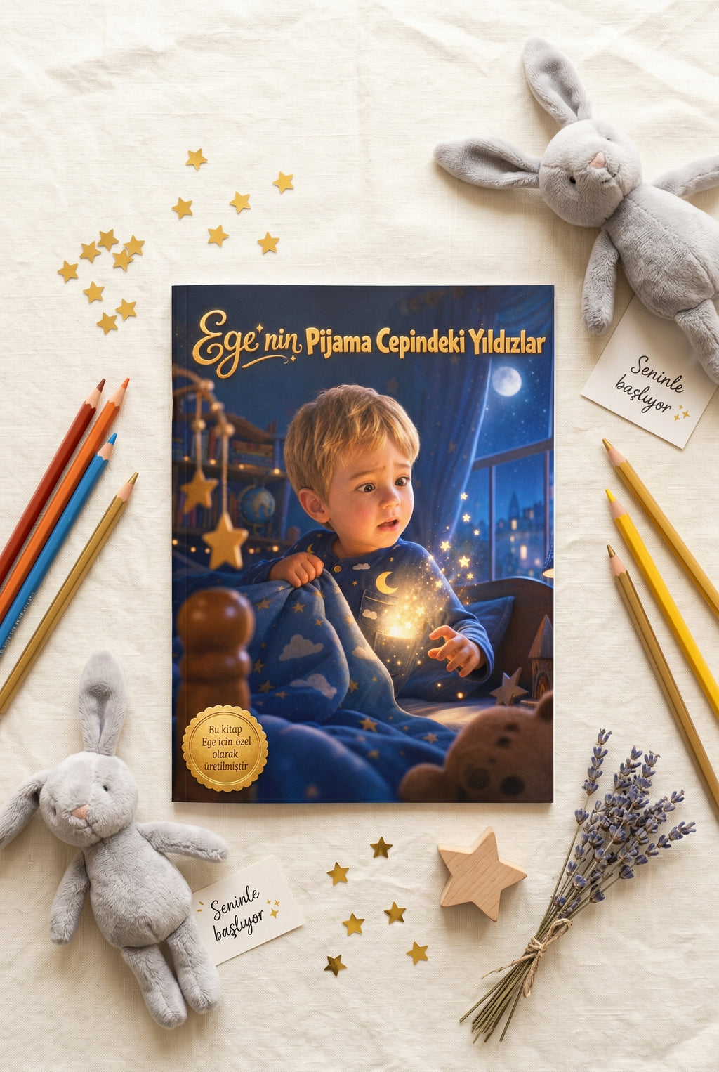 Ege'nin adına özel kitap, pijama ve yıldız projektörü ile birlikte yatakta özenle sergileniyor.